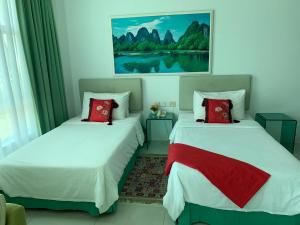 米里MCITI套房酒店的客房内的两张床和红色枕头