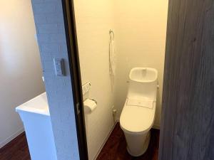 小樽Zenibako House 2f的浴室位于隔间内,设有白色卫生间。