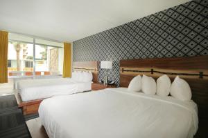默特尔比奇Holiday Shores的配有白色床单的酒店客房内的两张床