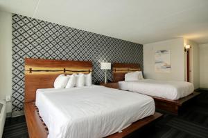 默特尔比奇Holiday Shores的一间卧室配有两张带白色床单的床