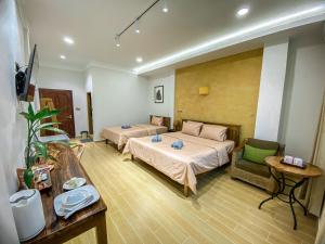 马德望Muni Residence & Spa的酒店客房,设有两张床和一张沙发