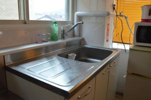 小樽Zenibako House 3F-RoomC的厨房配有不锈钢水槽和窗户