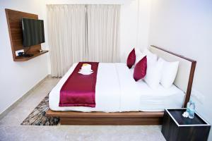 班加罗尔Villa Grand Hotel Near Kempegowda International Airport的一间酒店客房,配有一张床和一台电视