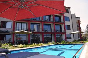 基加利Mythos Boutique Hotel的一座设有游泳池和红色建筑的酒店