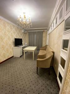 纳曼干ORZU HOTEL的客房设有书桌、椅子和桌子。