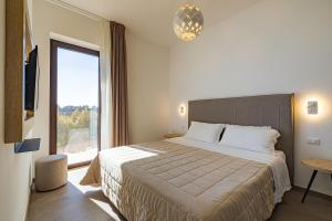 奥特朗托Agriturismo Vigna Corallo的一间卧室设有一张大床和一个大窗户