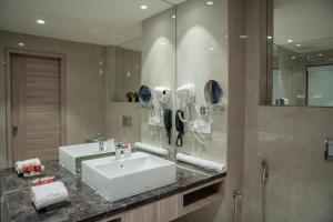 拉杰果德Lords Inn Rajkot的浴室设有白色水槽和镜子