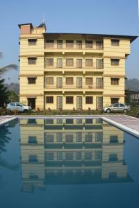 卡尔贾特Kalwars Millennials Park的一座黄色的大建筑,在游泳池里反射