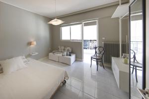 雅典Central Halandri apartment near all hospitals的一间卧室配有一张床、一张沙发和一张桌子