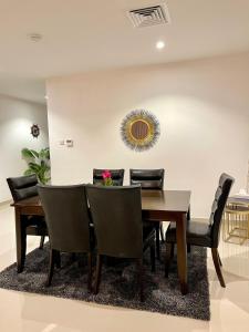 富查伊拉Iconic 4-bedroom villa with pool in Fujairah Palm的一间带木桌和椅子的用餐室