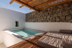 普拉迪斯亚罗斯Mykonos Drops的石头墙房的游泳池