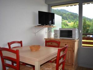 大博尔南Appartement Le Grand-Bornand, 1 pièce, 4 personnes - FR-1-241-176的带微波炉和电视的餐桌