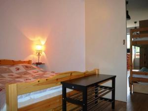 大博尔南Appartement Le Grand-Bornand, 1 pièce, 4 personnes - FR-1-241-176的一间卧室配有一张床和一张带台灯的桌子