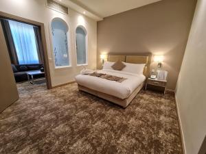 多哈Gloria Hotel & Suites Doha的一间卧室配有一张床、一张沙发和窗户。