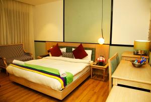 新德里AMARA HOTEL的一间卧室配有一张大床和一把椅子