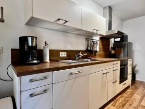Modernes Apartment mit besonderem Charme - 1A Guesthouse的厨房配有白色橱柜和水槽