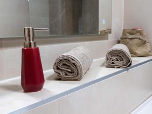 弗尔克马克特Jagerwirt rooms的浴室水槽上的红色瓶子和毛巾