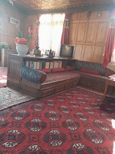 斯利那加Alif Laila Group of Houseboats, Srinagar的客厅配有沙发,铺在红地毯上