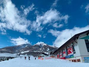 妙高蒙雷波斯别墅住宿加早餐旅馆的一群人在雪覆盖的山上滑雪