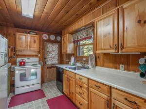 玛瑙湾Ons Huis Cabin的厨房配有木制橱柜、水槽和炉灶。