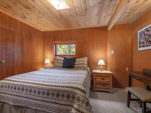 玛瑙湾Ons Huis Cabin的一间卧室设有一张床和木制天花板