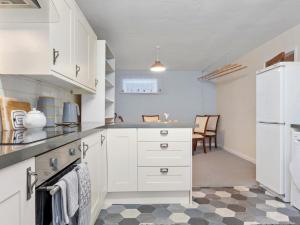 UlphaPass the Keys Cosy Home in the Idyllic Duddon Valley的厨房配有白色橱柜和台面