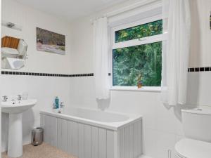 UlphaPass the Keys Cosy Home in the Idyllic Duddon Valley的白色的浴室设有浴缸、水槽和窗户。