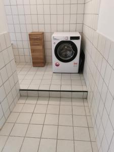 FrohburgGästewohnung Schönfeld的瓷砖浴室内的洗衣机和烘干机