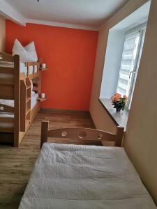 FrohburgGästewohnung Schönfeld的一间卧室拥有橙色的墙壁、一张床和窗户