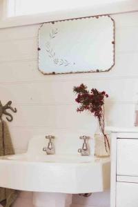 布里德波特Quaint and intimate 1-bed seaside cottage的浴室设有白色水槽和镜子