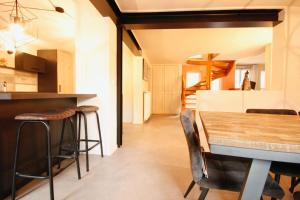 鲁法克Gîte Aux Quatre Vents avec Terrasse的厨房以及带木桌和凳子的用餐室。