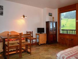 大博尔南Appartement Le Grand-Bornand, 2 pièces, 5 personnes - FR-1-241-147的一间卧室配有一张床、一张书桌和一台电视