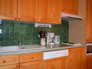 大博尔南Appartement Le Grand-Bornand, 2 pièces, 5 personnes - FR-1-241-147的厨房配有木制橱柜和绿色瓷砖