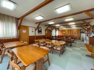 饭山市福泽勒夫雷旅馆的用餐室配有木桌和椅子
