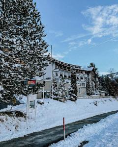 阿尔高内的伊门施塔特Rothenfels Hotel & Panorama Restaurant的雪中一座建筑物,前面有标志