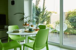 努马纳Villa Ulisse - Suites - Luxury B&B的一间带桌子和绿色椅子的用餐室