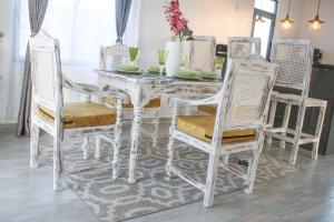 蒙巴萨Shany’s Villa 3bdrm with private swimming pool的白色的餐桌,配有两把椅子和白色的桌子