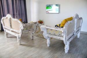 蒙巴萨Shany’s Villa 3bdrm with private swimming pool的两个白色椅子在房间旁边