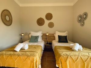 Lachapelle-sous-AubenasMas de Veyras - Gîtes 5 étoiles en Ardèche的一间卧室配有两张带黄床单的床