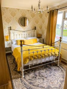 约克Immaculate 3-Bedroom Private Lodge near York的一间卧室配有一张带黄色床单和镜子的床