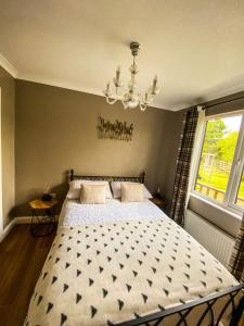 约克Immaculate 3-Bedroom Private Lodge near York的一间卧室配有一张床和一个吊灯