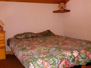 大博尔南Appartement Le Grand-Bornand, 2 pièces, 6 personnes - FR-1-241-21的一间卧室配有一张带花卉床罩的床