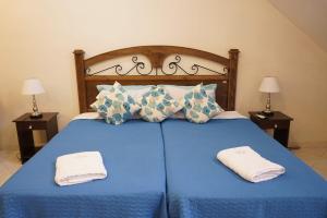 LuqueSol de Luque Casa-hotel的蓝色的床,上面有两条毛巾
