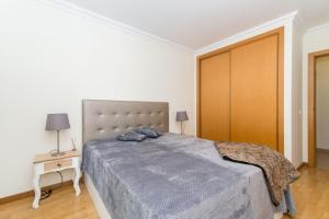 ConceiçãoCasa Azevedo by ALGARTUR的一间卧室配有一张床和一个木制衣柜
