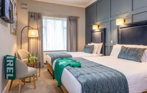都柏林赫尔伯特山酒店的酒店客房,配有两张床和椅子