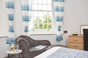 尚克林卢康蓓庄园乡间别墅酒店的卧室配有床、椅子和窗户。