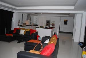 象岛The Terrace, spacious 3 bedroom luxury pool villa的客厅配有黑色沙发和红色枕头