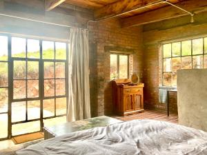 诺丁汉路Rose Mountain Cottage的一间卧室设有一张床和一些窗户。