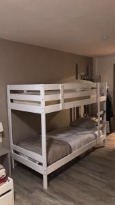 莱代塞尔Au bout du bois Piscine sauna hammam accessible en saison et le logement accessible toute l annee的客房内的2张白色双层床