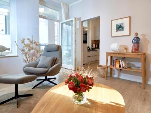 奥斯赛拜-塞林Ferienwohnung AMAPOLA - Villa Odin的客厅配有椅子和一张带花瓶的桌子